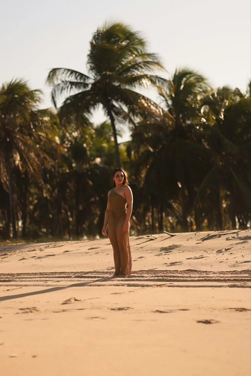 Dra. Laisy Velar de pé na praia no fim de tarde